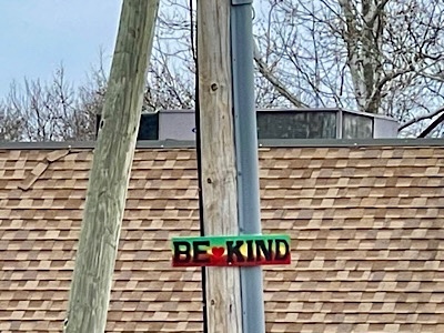 Hand-painted sign reads “be kind.”