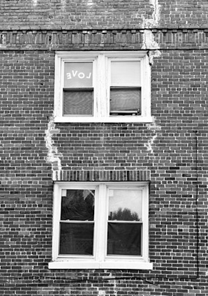 Photo of brick building with love spelled backwards in one of the windows 