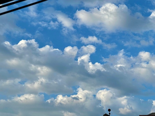 Photo of clouds—some heart-shaped—against blue sky 