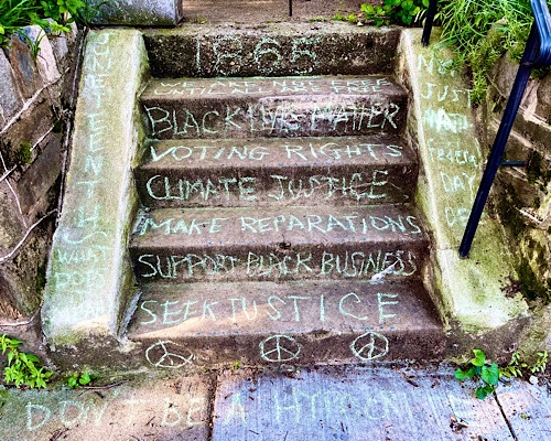 Chalk drawing on stairs says:  1865, we are not free until all are free; Black Lives Matter, voting rights, climate justice, make reparations, support Black business, seek justice, don’t be a hypocrite, Juneteenth—not just a Federal holiday 