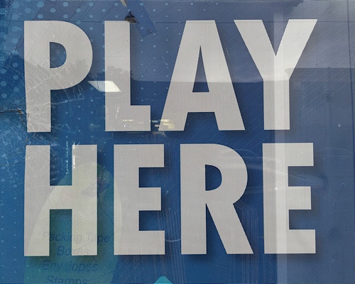 Photo of sign that reads “play here”