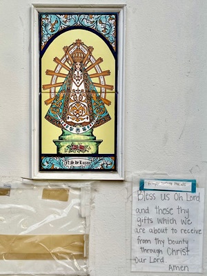 Picture of Saint Lujan and a sign that reads, “Bless us oh Lord and these thy gifts which we are about to receive from thy bounty through Christ Our Lord.”