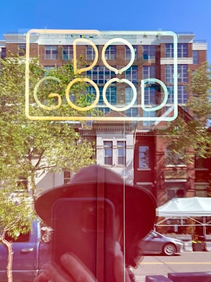 Neon sign in shop window reads, “do good.”