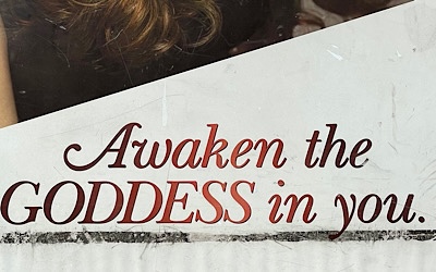 Photo of part of advertising sign that reads, “awaken the goddess in you.”