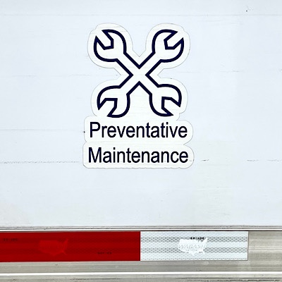 Photo of sign on side of van with a picture of two crossed wrenches, which reads “Preventive Maintenance “)
