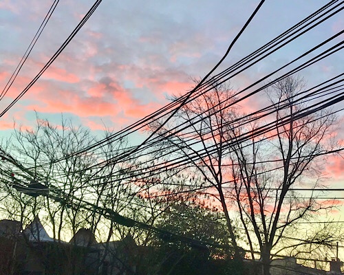 Sunrise with telephone wires in row house alley 