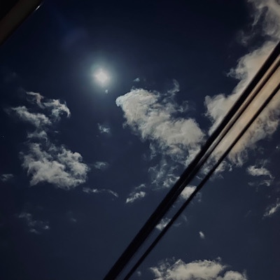 Photo of bright night sky with full moon, clouds, and telephone wires 
