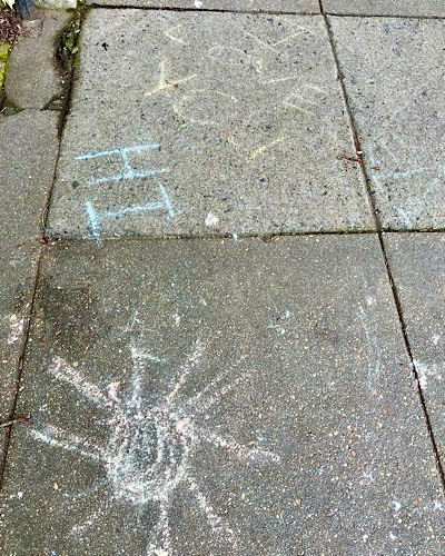 Drawing on sidewalk reads “I love you, hi”