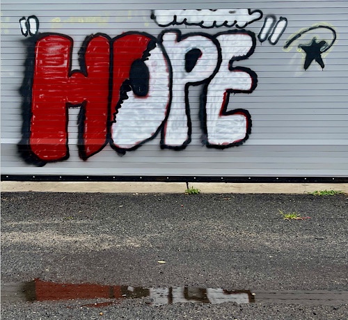 Graffiti on a closed garage door reads:  “HOPE”