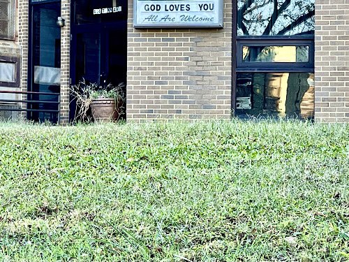 Sign on urban church reads “God loves you; all are welcome.”