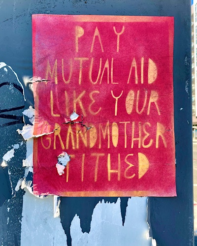 Handmade sign reads, “pay mutual aid like your grandmother tithed”